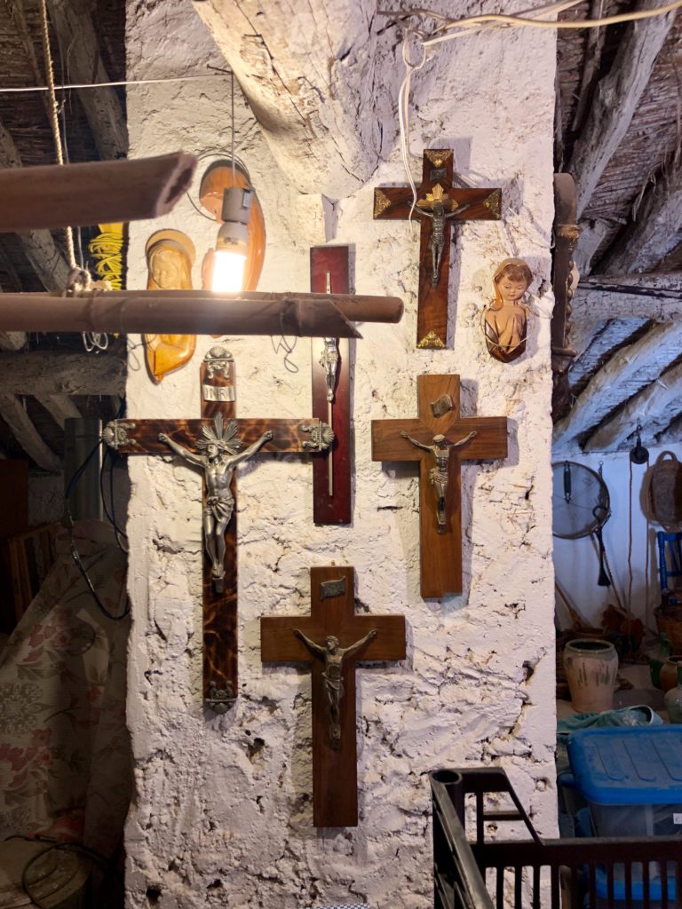 An arrangement of Christian crosses on the column of an old loft.