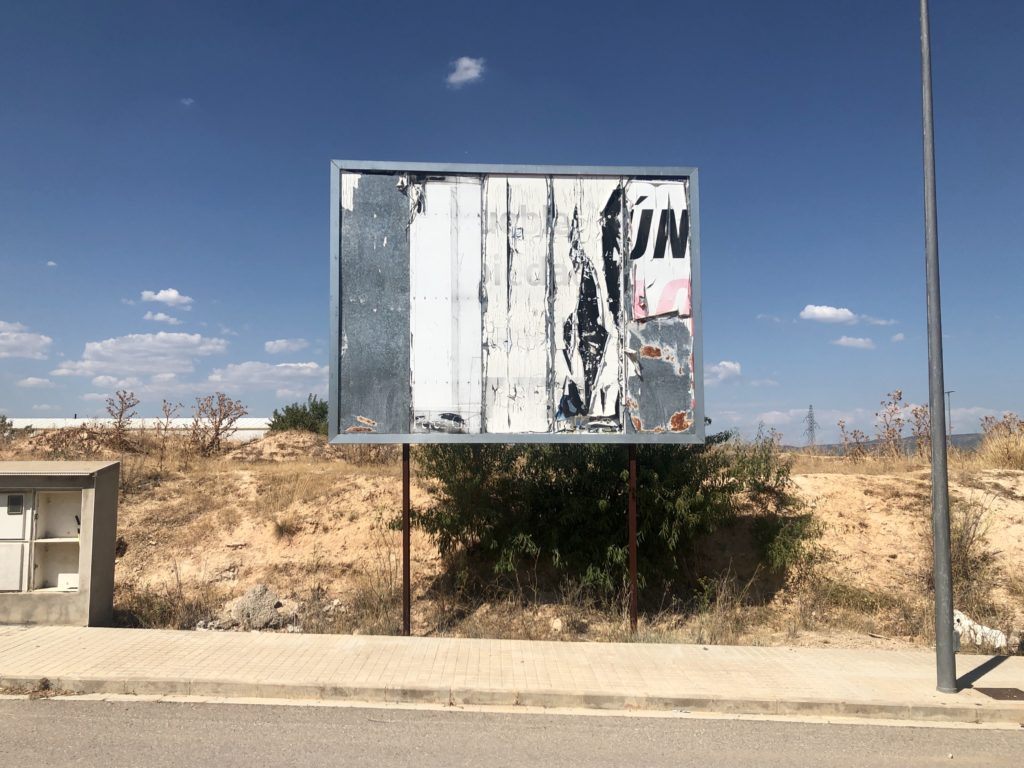 An abandoned billboard's various layers are exposed after it has been left unused for a long time.