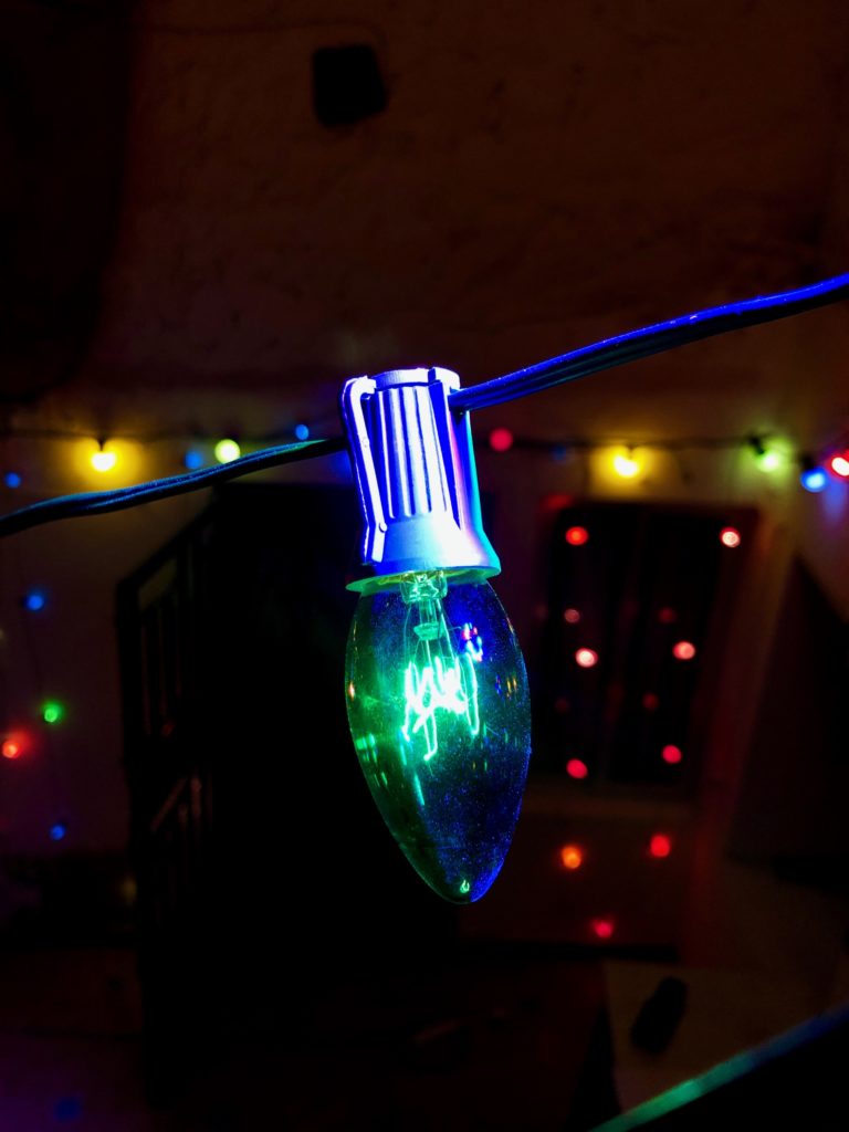A translucent green bulb is illuminated by a purple light.