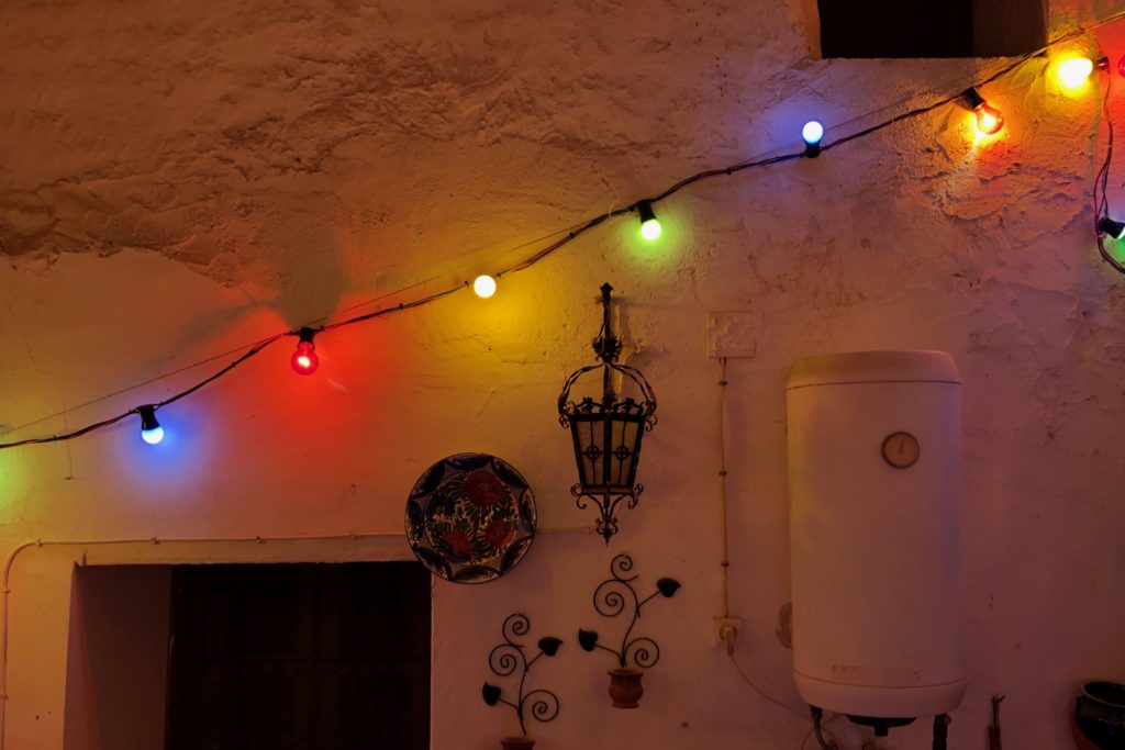 A string of red, green, yellow, and blue lights runs diagonally up a wall.