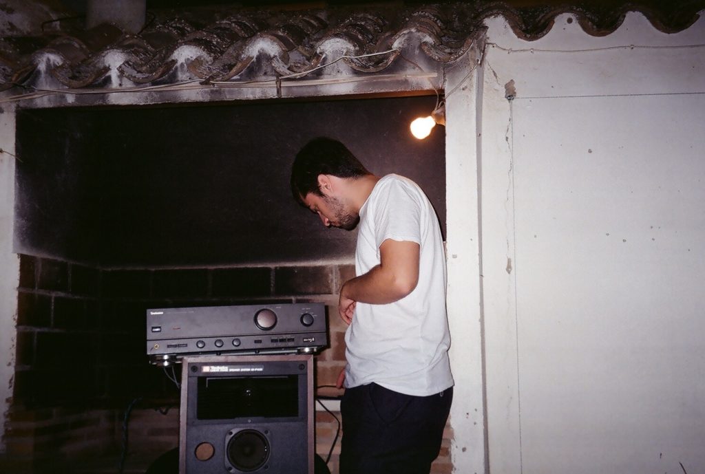 A film photo of Roberto setting up a speaker system.