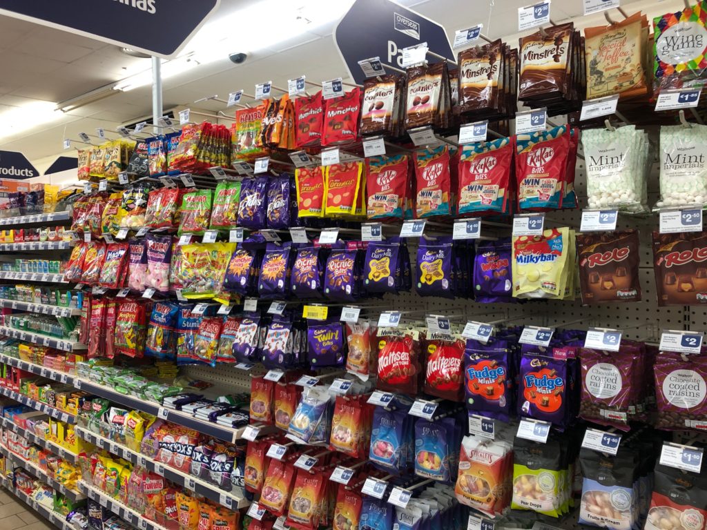 A collection of bags of British snacks and chocolates.