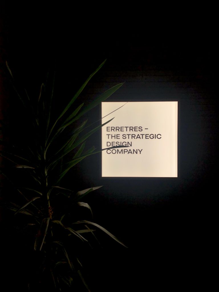 An illuminated sign reading "Erretres – The Strategic Design Company".