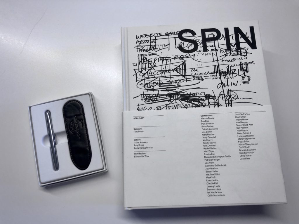 A pen in a box and Spin 360 design book.