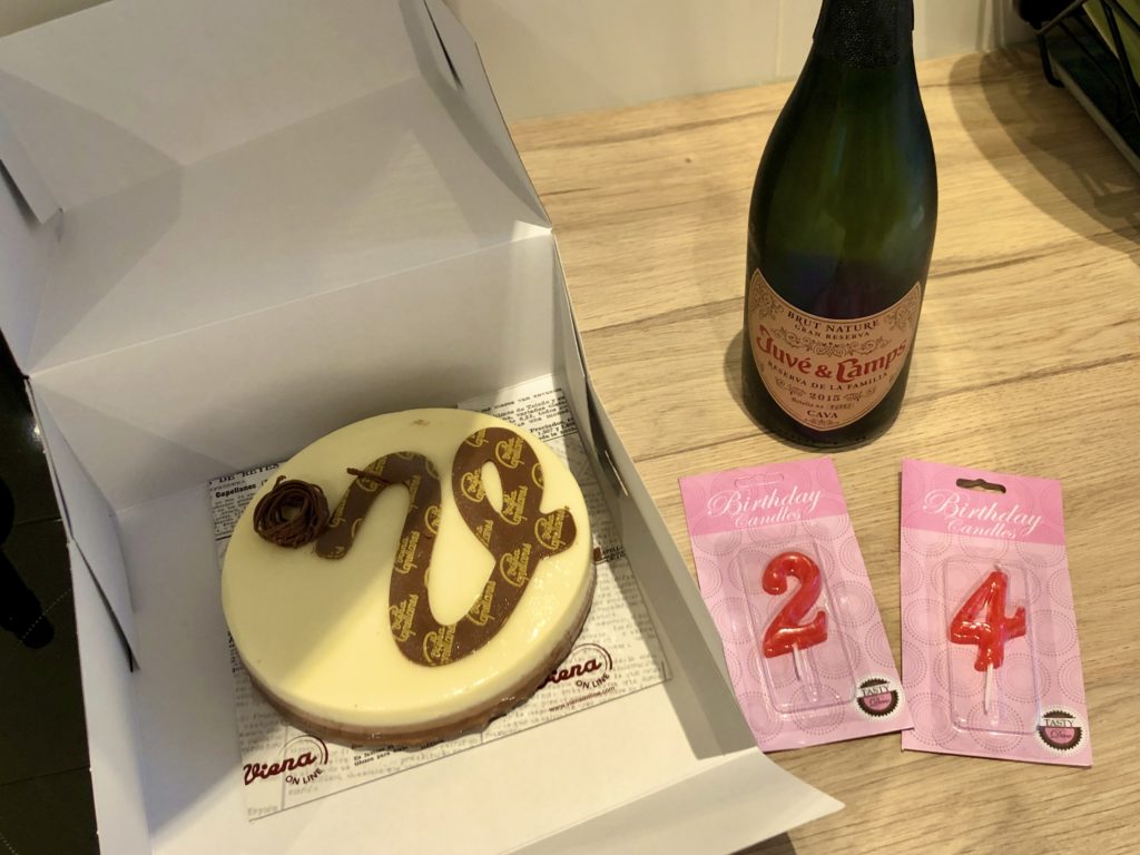 A cake, candles reading "24", and a bottle of cava.
