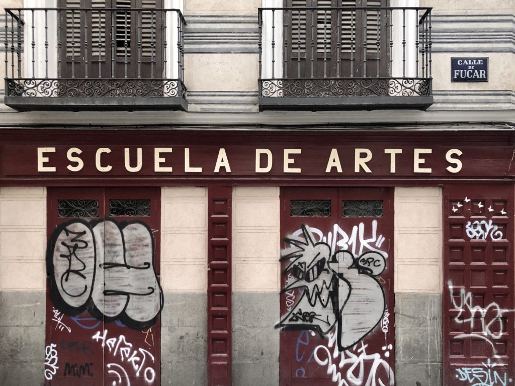 A sign reading "Escuela de artes" (Art School) on a facade in the historic centre of Madrid, Spain.