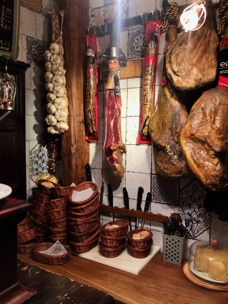 Cured ham and garlic hangs from the wall in Bodega de la Ardosa.