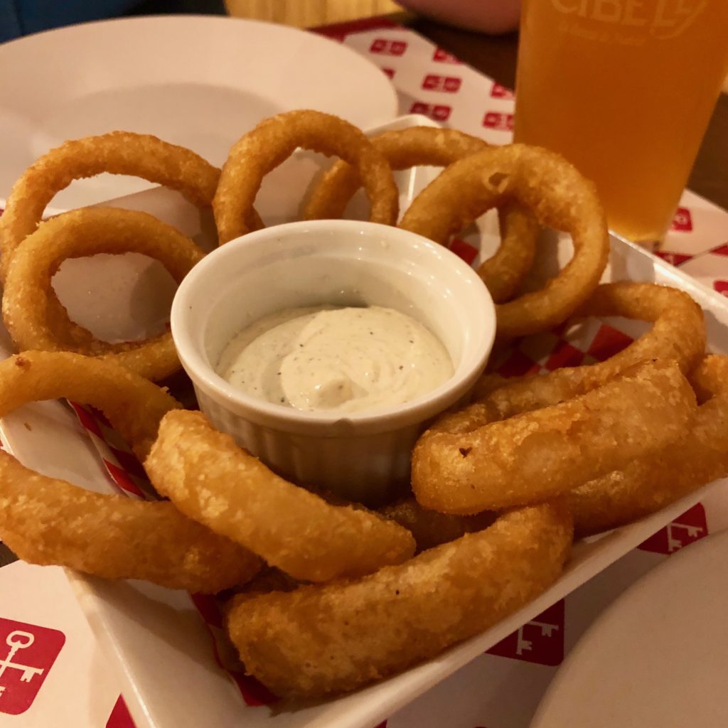 A bowl of onion rings and dip.