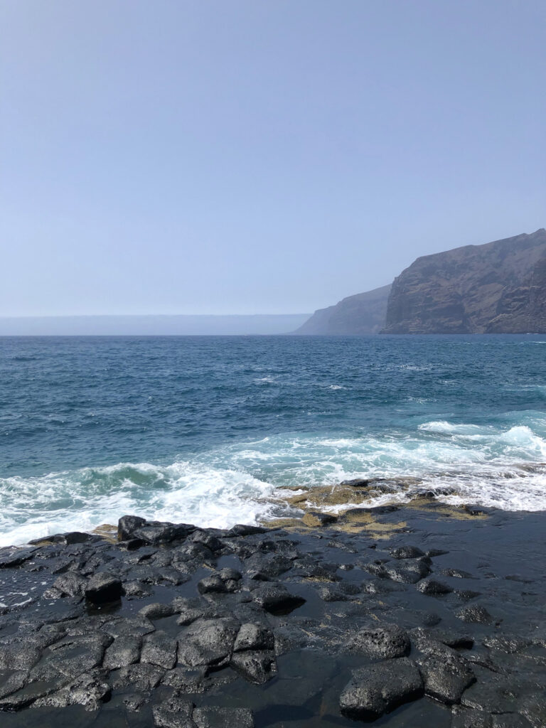 The sea breaks over black volcanic rocks in Tenerife.